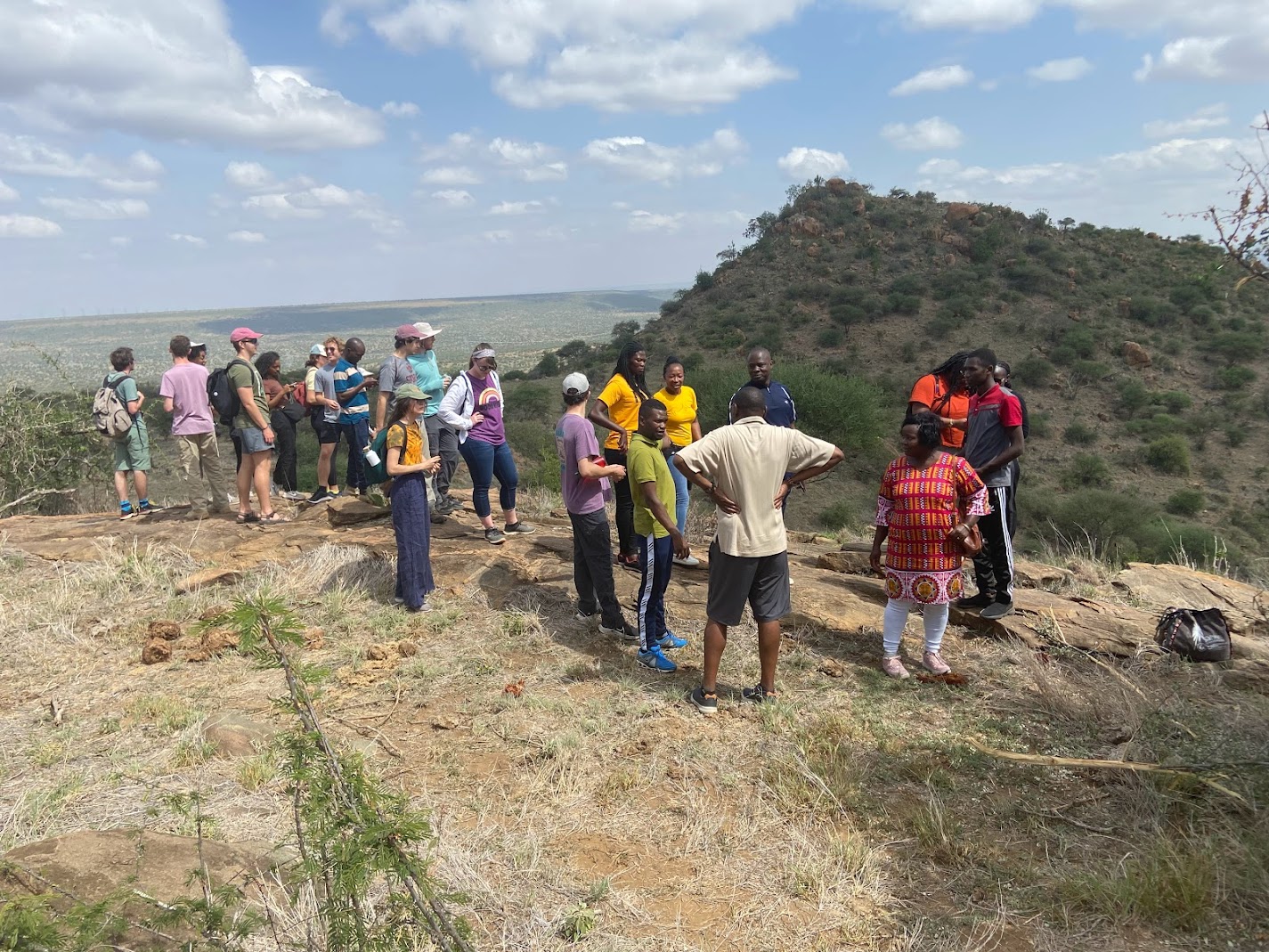 Students on a hilltop in Kenya listen to a lecture.