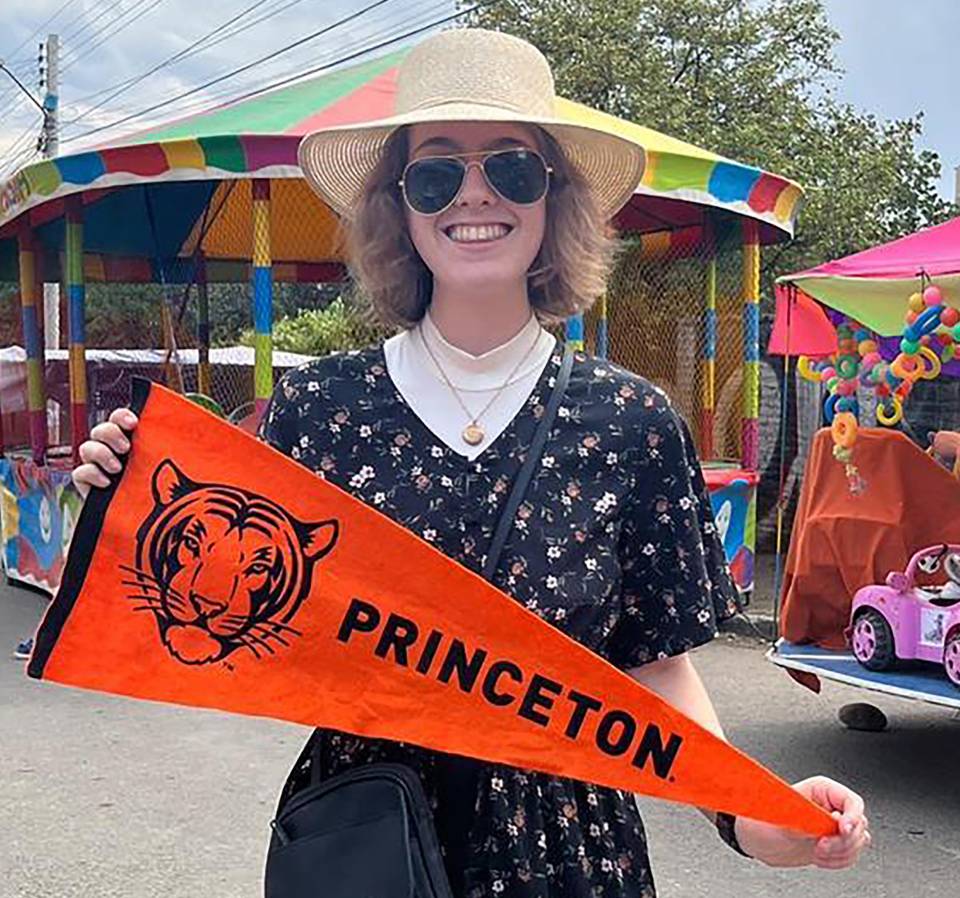 Mary Grace Walker, a Bridge Year student in Bolivia, holds a Princeton pennant while attending the Festival de San Miguel for the patron saint of Tiquipaya.