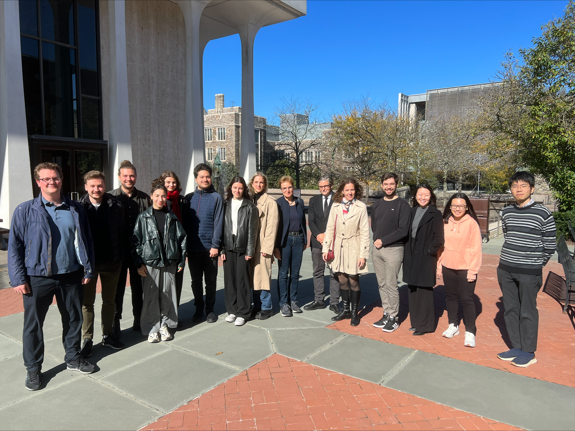 A group of about 15 stand in front of the Roberson Building on Princeton's campus.