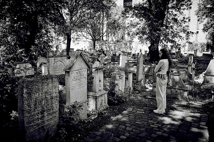 a princeton student reads the headstone in a Jewish cemetery. 