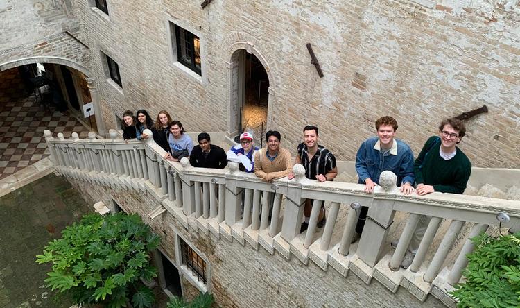 Students smiling while standing on a concrete staircase