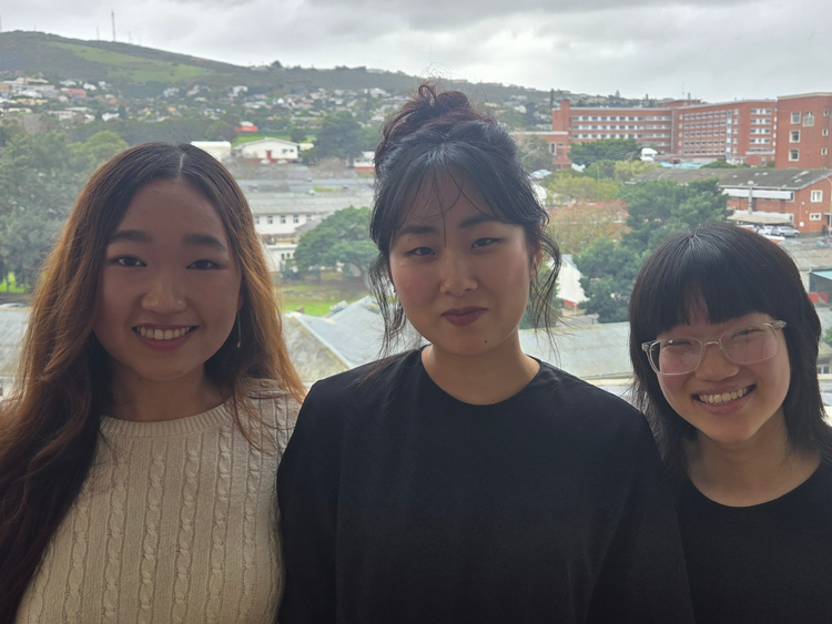 three women with a river in the background