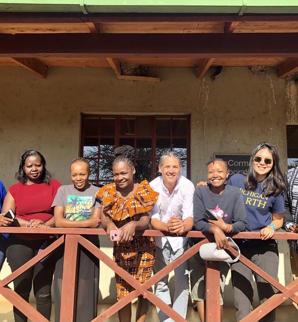 a group of eight people standing on a wooden balcony.