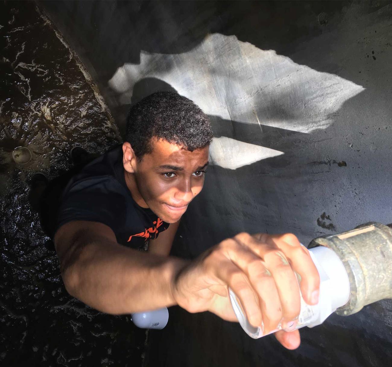 Student working on pipes in the Dominican Republic