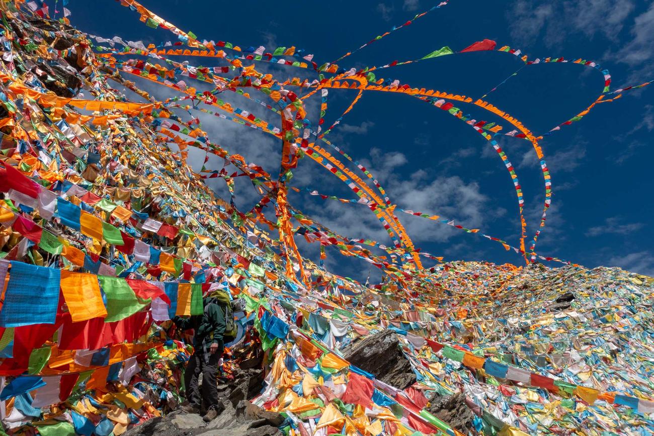 Multicolored flags wave on a mountainside in China