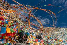 Multicolored flags wave on a mountainside in China