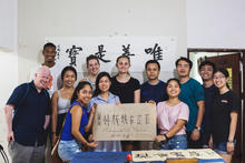 A group shot of about 10 people holding a sign with Chinese characters