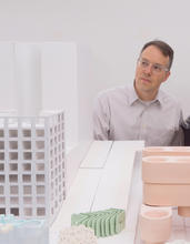 Michael Meredith looking at an architectural model