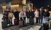 A picture of travellers posing with their luggages.