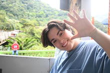 A picture of a person waving at the camera.