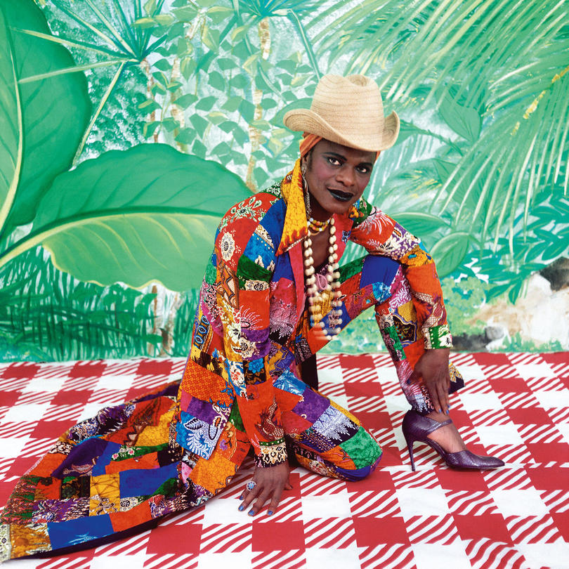 Artist appears in self portrait wearing brightly colored clothing