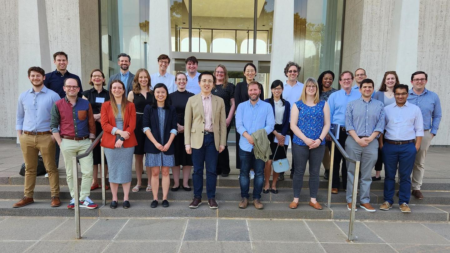 A group of scholars are arrayed in front of the iconic SPIA building