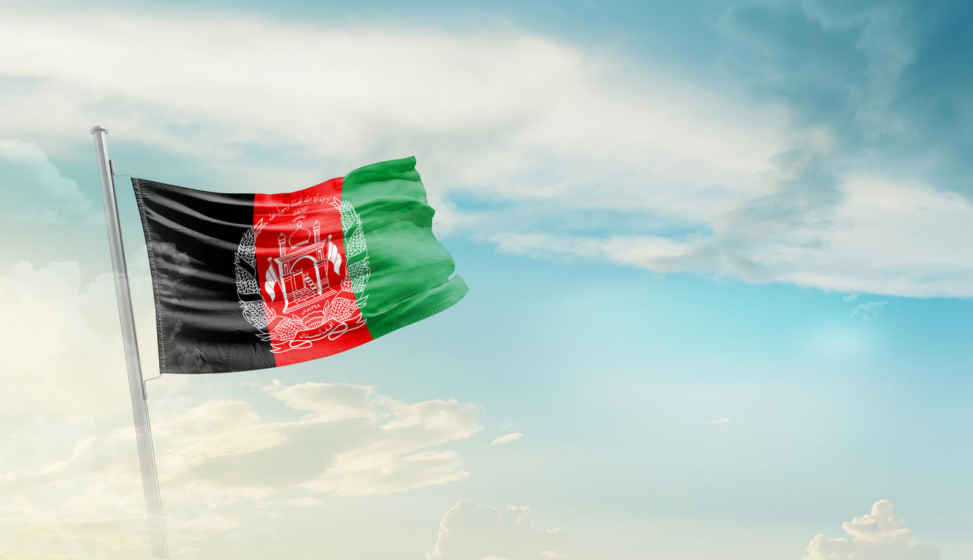 The Afghan flag waves against a blue sky.
