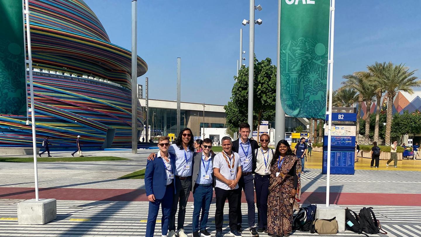 A group of seven in front of a large arena in Dubai