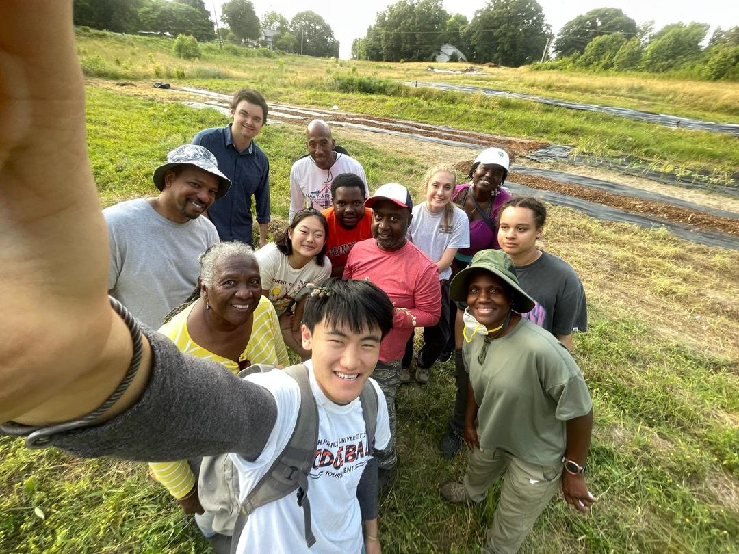 A group photo with Justin Yang in a grassy background