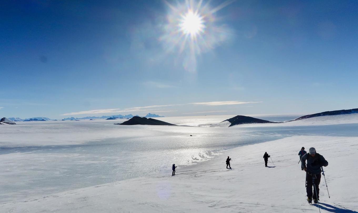 Four people in cross-country skis on a arctic landscape