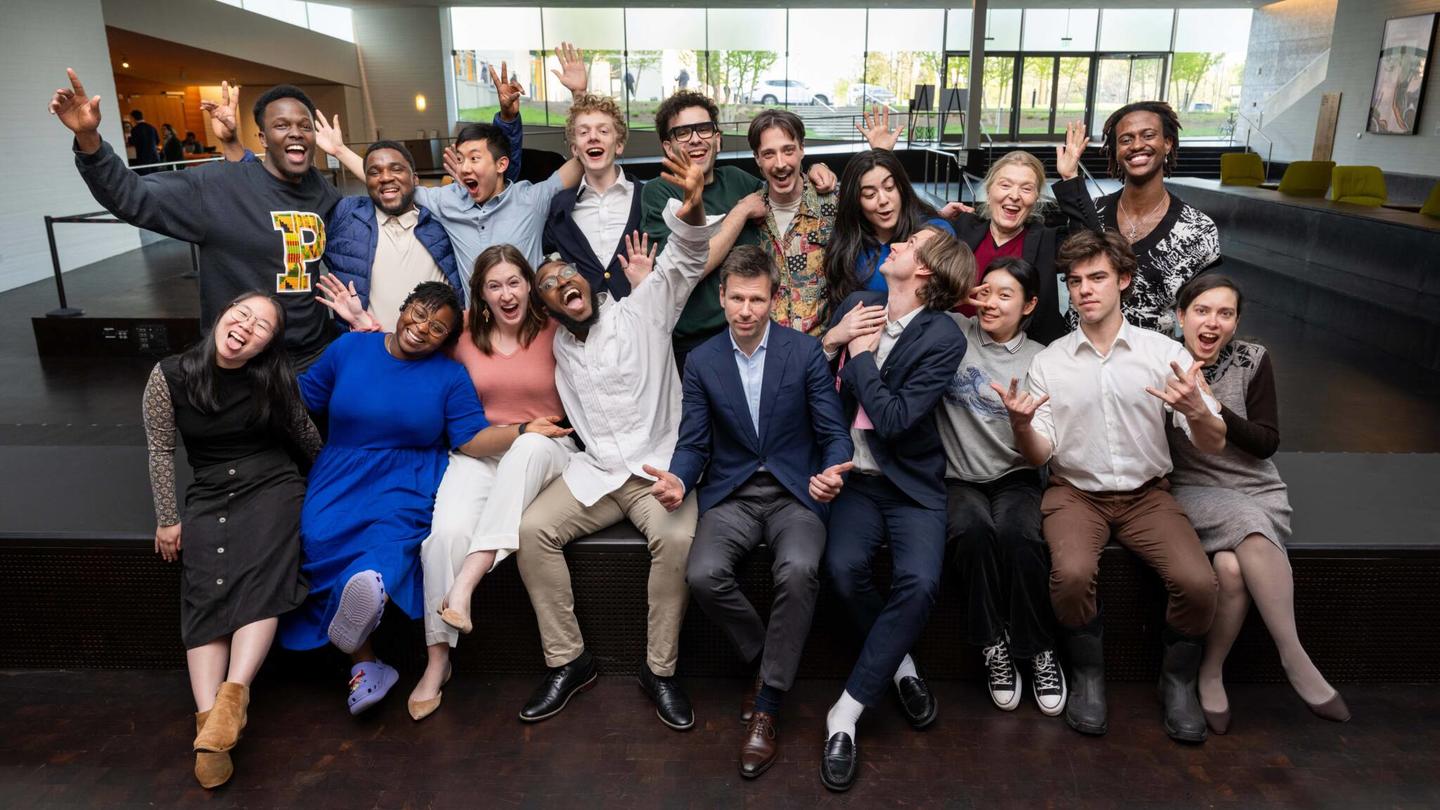 A large group takes a playful photo