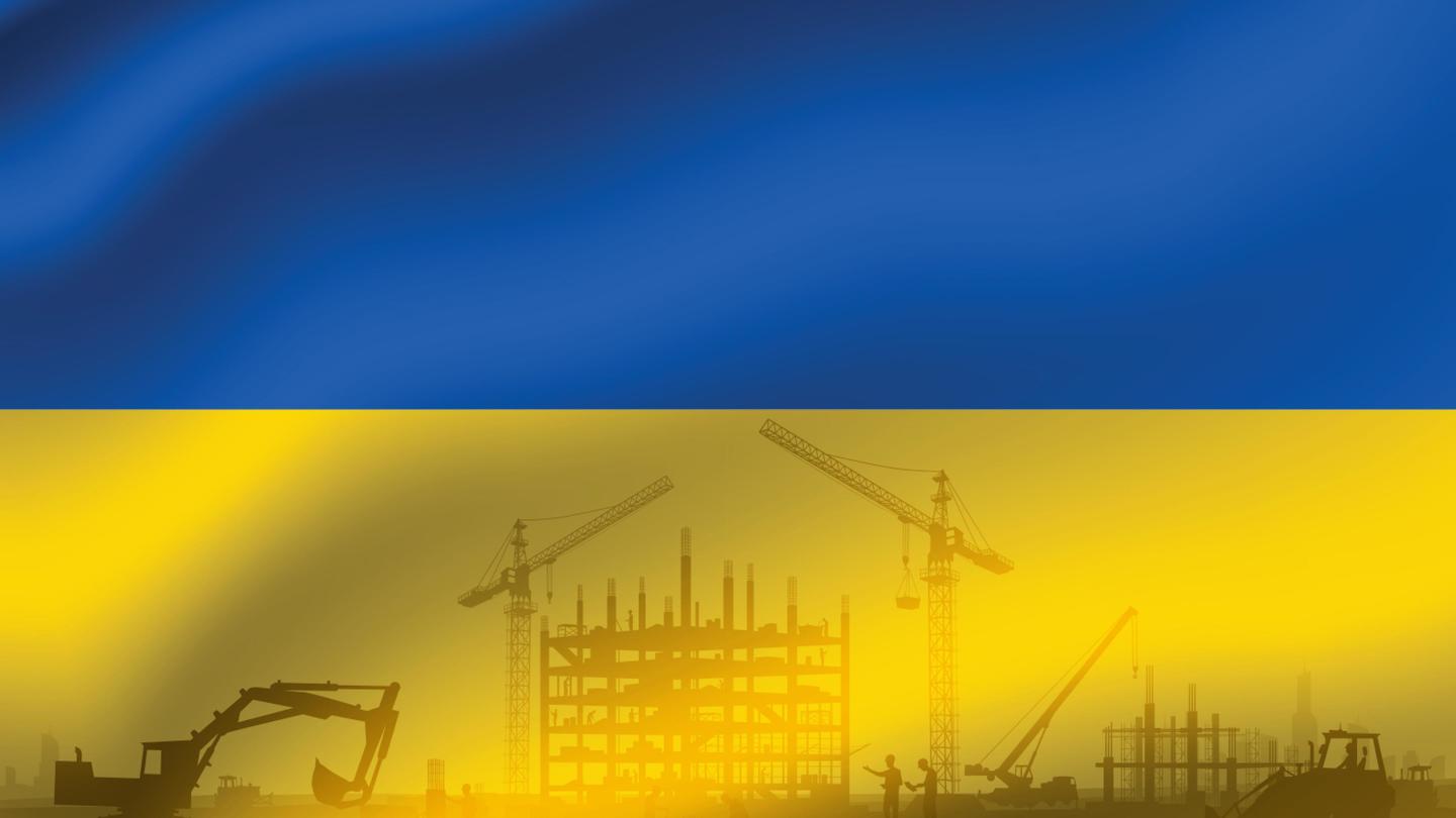 a ukrainian flag with construction machinery silhouetted on it 