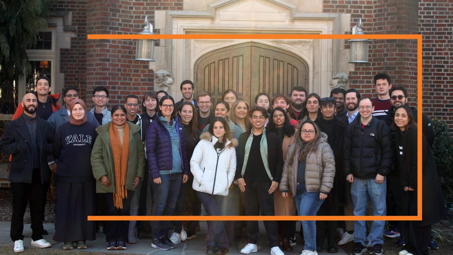 A large group of students pose outside of a Princeton building