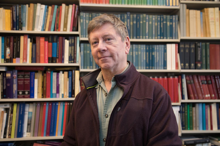 John Haldon infront of a bookshelf