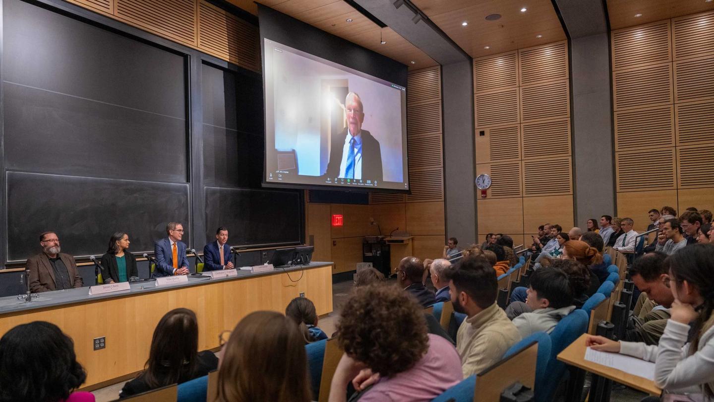 Auditorium filled with people; Hopfield on a large zoom screen