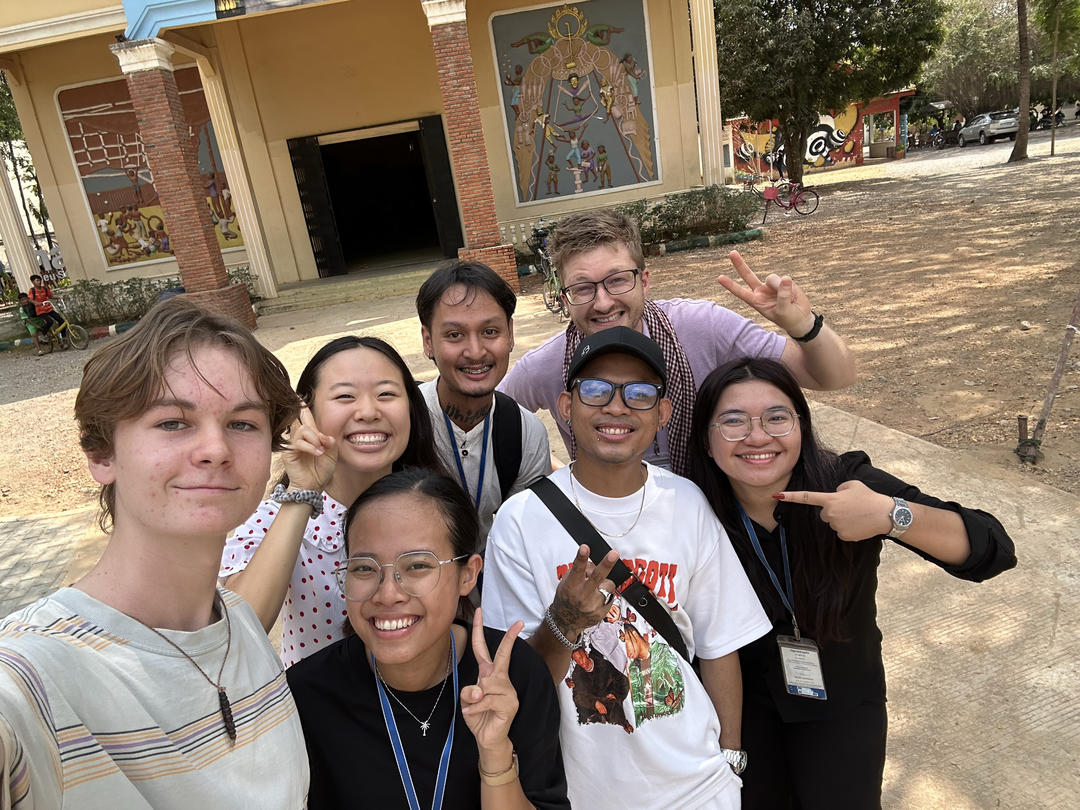 Eliot Witherspoon '28 (left) and Soree Kim '28 (top left) with the Phare communications team and Cambodian musical artist and Phare alum, Vanthan (front, second from right)
