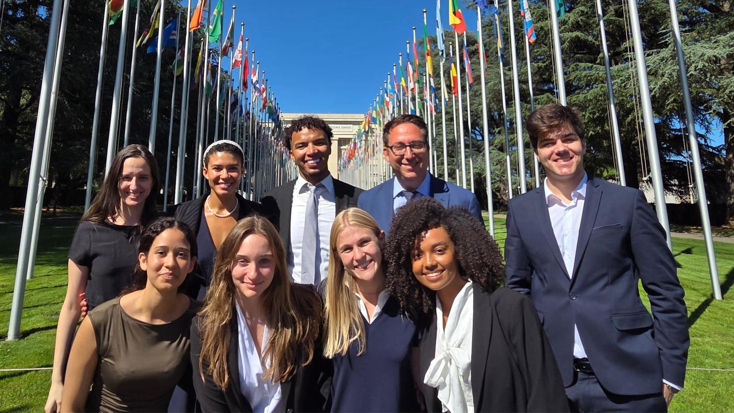 A group of 10 students and their professor in front of the UN