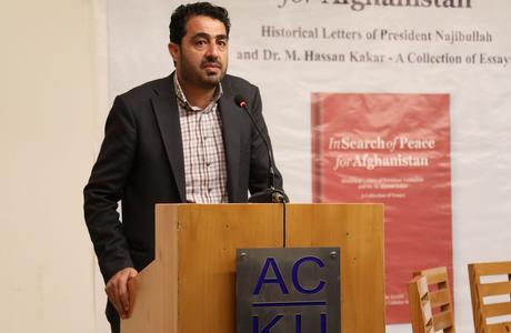 Abdul Wahid Wafa standing behind a podium at an event.