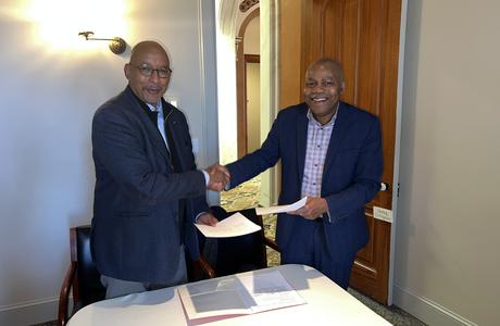 Two men shake hands in an office