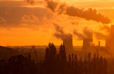 Nuclear power plants in silhouette against an orange sunset