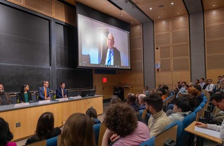 Auditorium filled with people; Hopfield on a large zoom screen