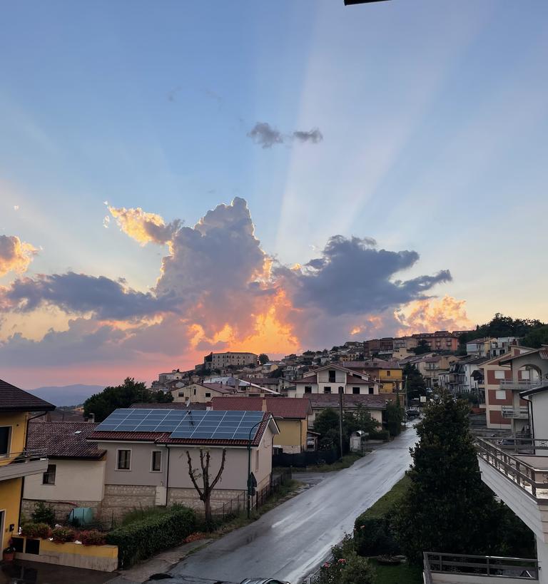 the sun rising over a small italian villiage