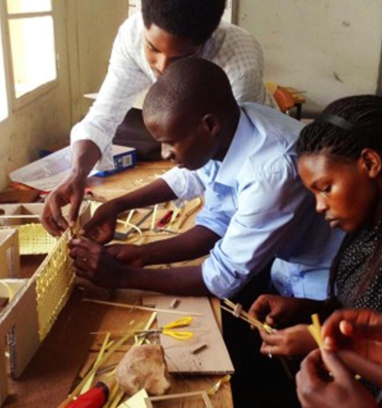 A group of four people building a housing model